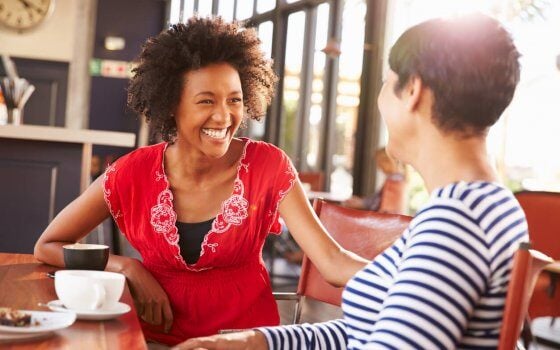 Two female friends talking at a coffee shop