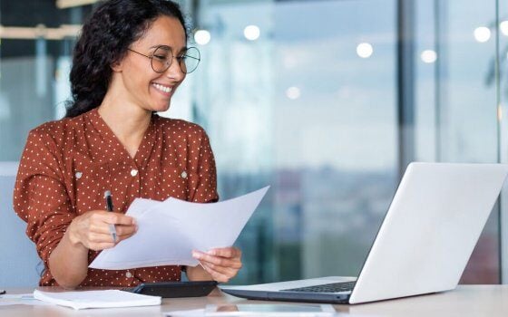 Successful satisfied and happy business woman working inside modern office, hispanic woman in glasses and shirt using laptop at work,