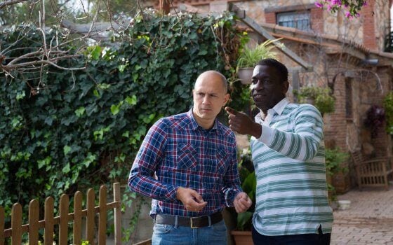 Two serious farmers standing outdoors, talking about some current issues on homestead