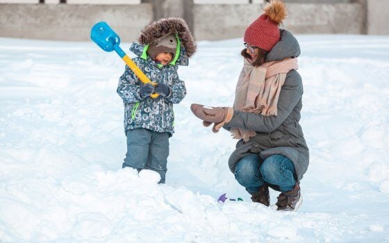 Family mom and child winter activity having fun together in the snow