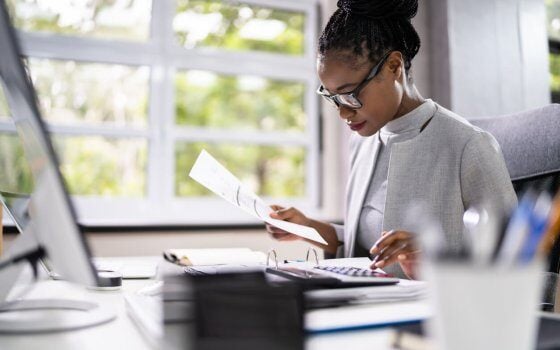 African American Accountant Or Auditor With Calculator