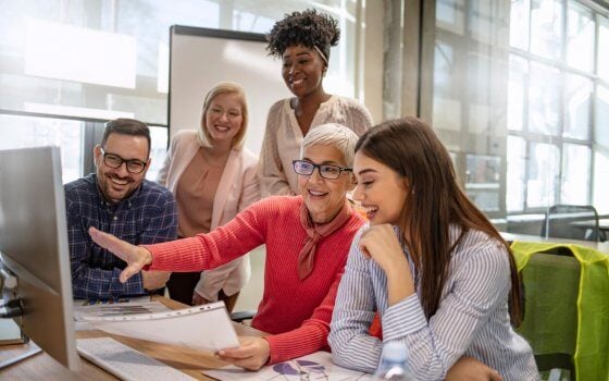 Senior designer giving some new ideas about project to her partners in conference room. Business people discussing over new business project in office. Group of businesspeople or designers work with new startup project in office