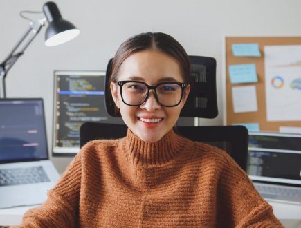 Portrait young Asian woman developer programmer, software engineer, IT support, wearing glasses look at camera and smile enjoy working at home.